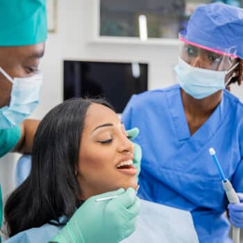 lead dental assistant helping dentist