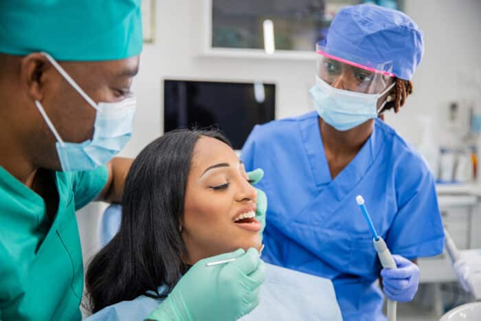 lead dental assistant helping dentist